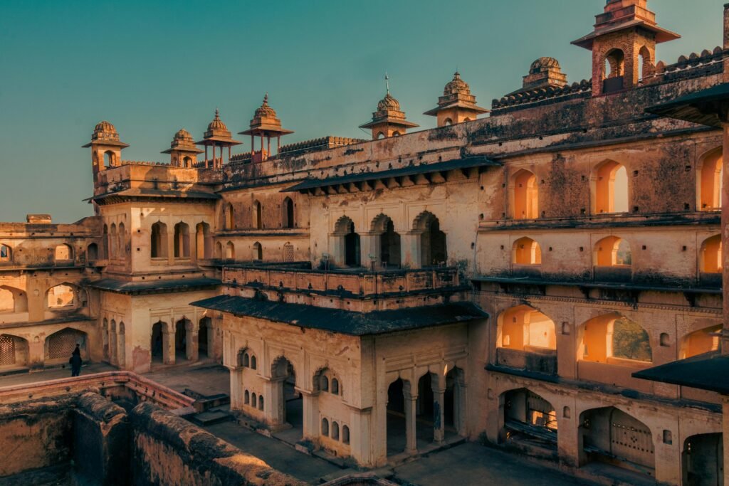 Stunning view of Raja Mahal in Orchha, showcasing intricate Rajput architecture during sunset.